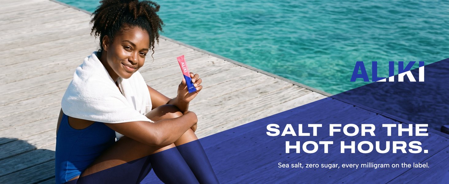 Woman after a swim on sunlit dock planks, holding an ALIKI Grapefruit stick