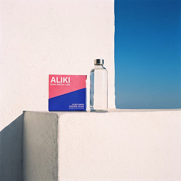 The same ledge at 1 pm, shortest shadow, ALIKI carton and a clear bottle in hard sun