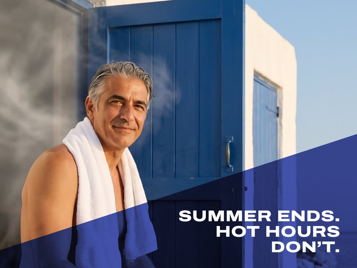 Man resting by a seaside sauna in the evening sun, towel around his neck