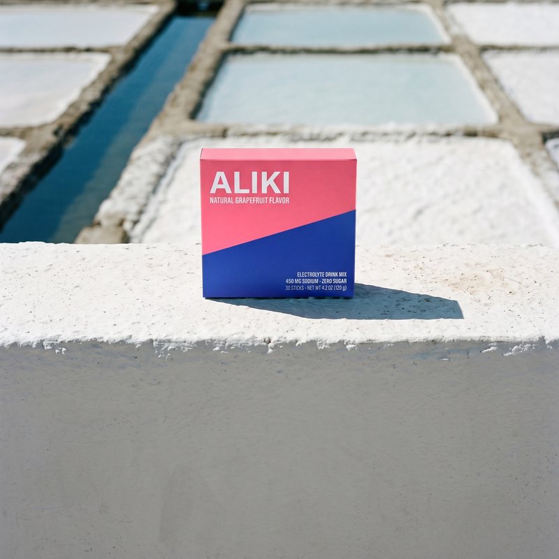 ALIKI Grapefruit carton on a whitewashed salt-pan dike, salt pans behind it