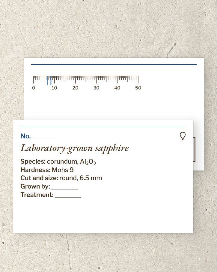 The Corund label card, front and back with its 50 mm scale
