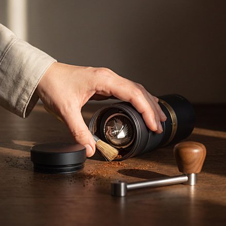 Hand brushing the open burr chamber of the Halden One with a small brush