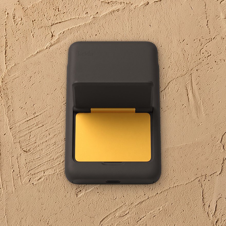 Kelda 37 in Soot, stand open to the marigold inside, on lime plaster
