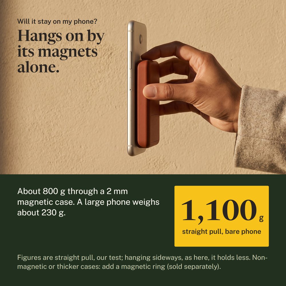 Hand holding the Kelda 37 pack, a phone hanging beside it on the magnets alone
