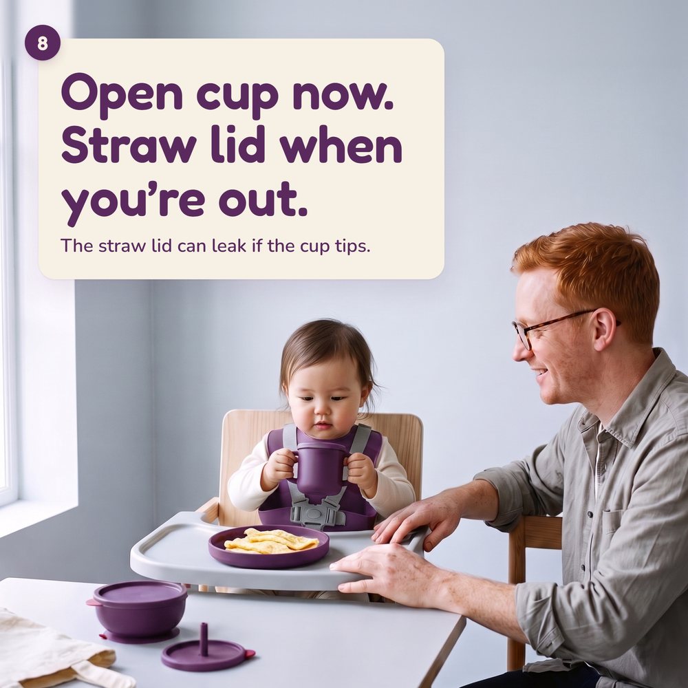 10-month-old holding the Linnet open cup by both handles, father beside her