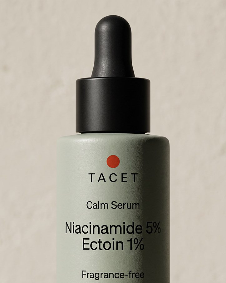 Close view of the Tacet Calm Serum bottle shoulder, black dropper collar and vermilion dot