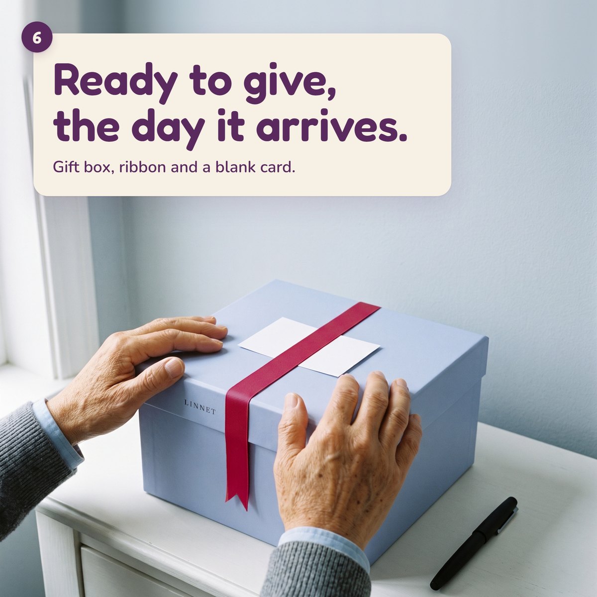 AI-generated hands resting on the Linnet gift box, a blank card under the raspberry ribbon